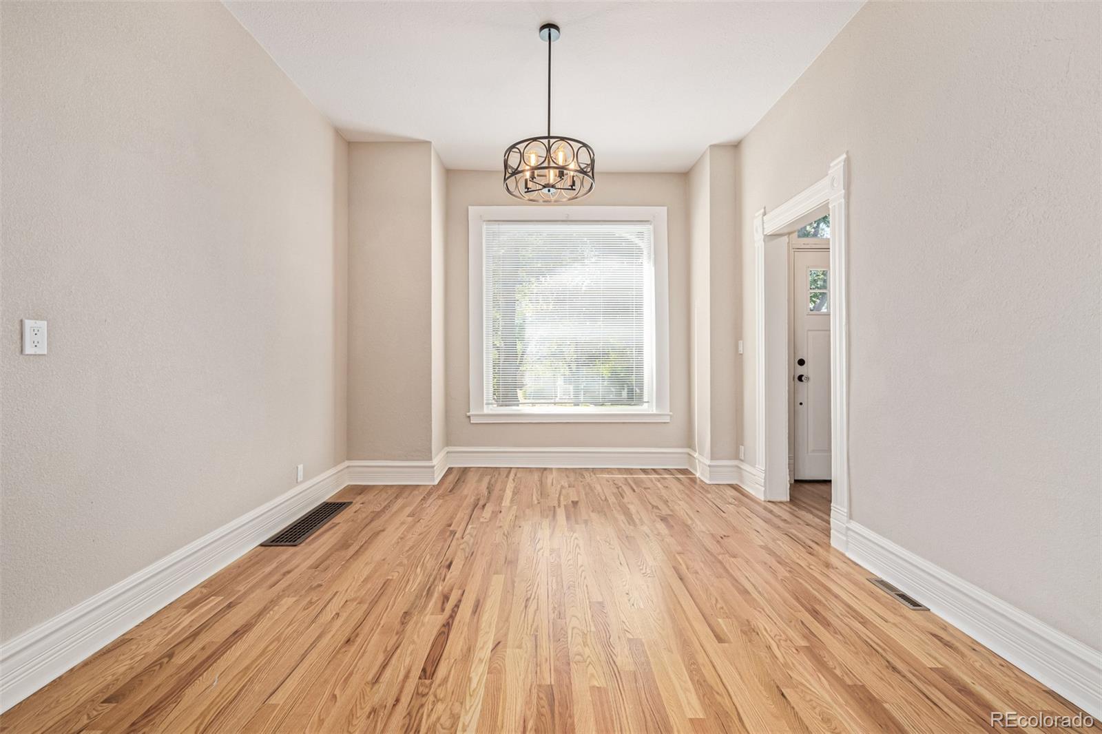 3854 Cook Street Denver, CO 80205 - Photo 6 of 42 a view of an empty room with window and wooden floor