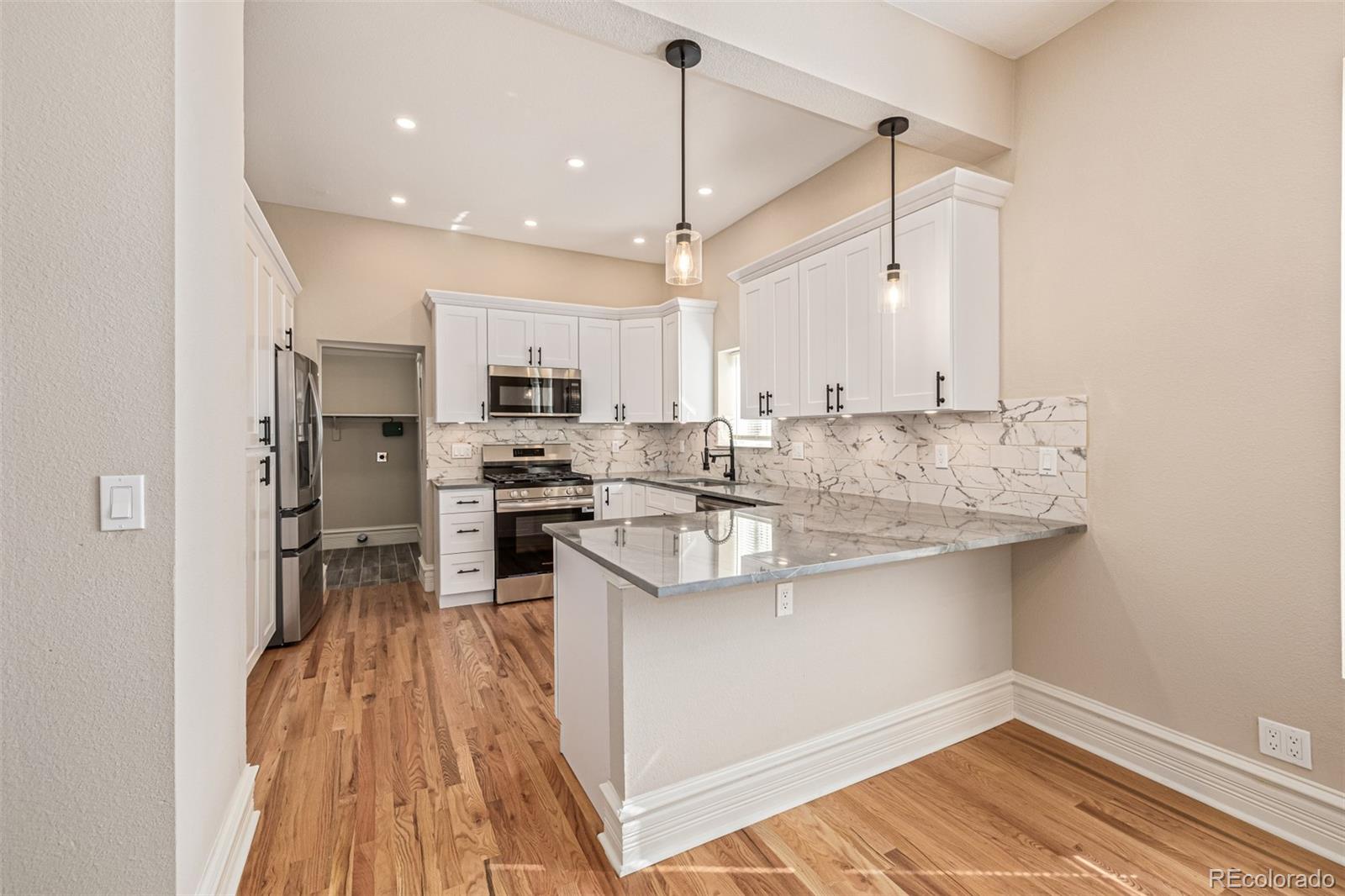 3854 Cook Street Denver, CO 80205 - Photo 10 of 42 a kitchen with stainless steel appliances granite countertop a sink stove and refrigerator