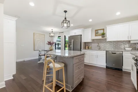 a kitchen with granite countertop cabinets a sink and stainless steel appliances