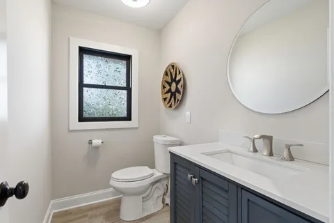 a bathroom with a toilet a sink and mirror