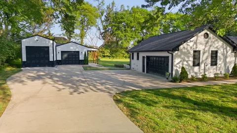 a front view of a house with a garden and trees