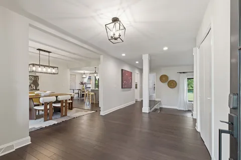 a view of a livingroom with furniture wooden floor windows and chandelier