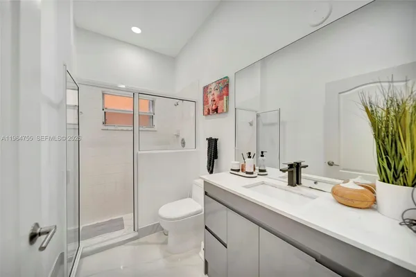 a kitchen with stainless steel appliances granite countertop a stove top oven a sink dishwasher and a refrigerator with wooden floor