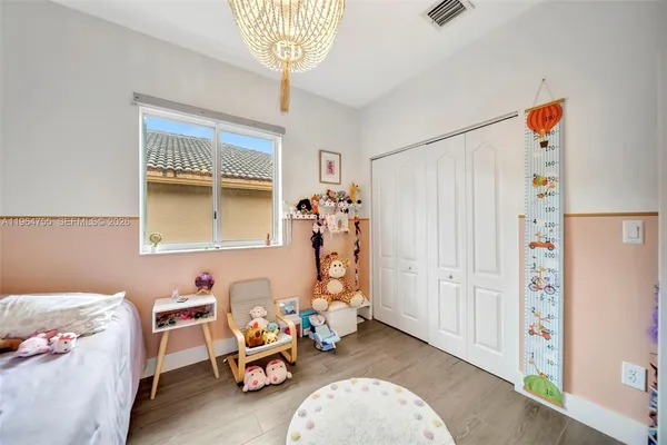 a spacious bedroom with a bed and a chandelier