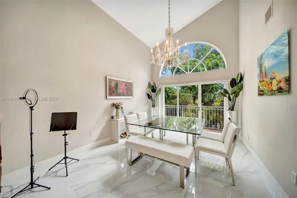 a view of a dining room with furniture a chandelier and wooden floor