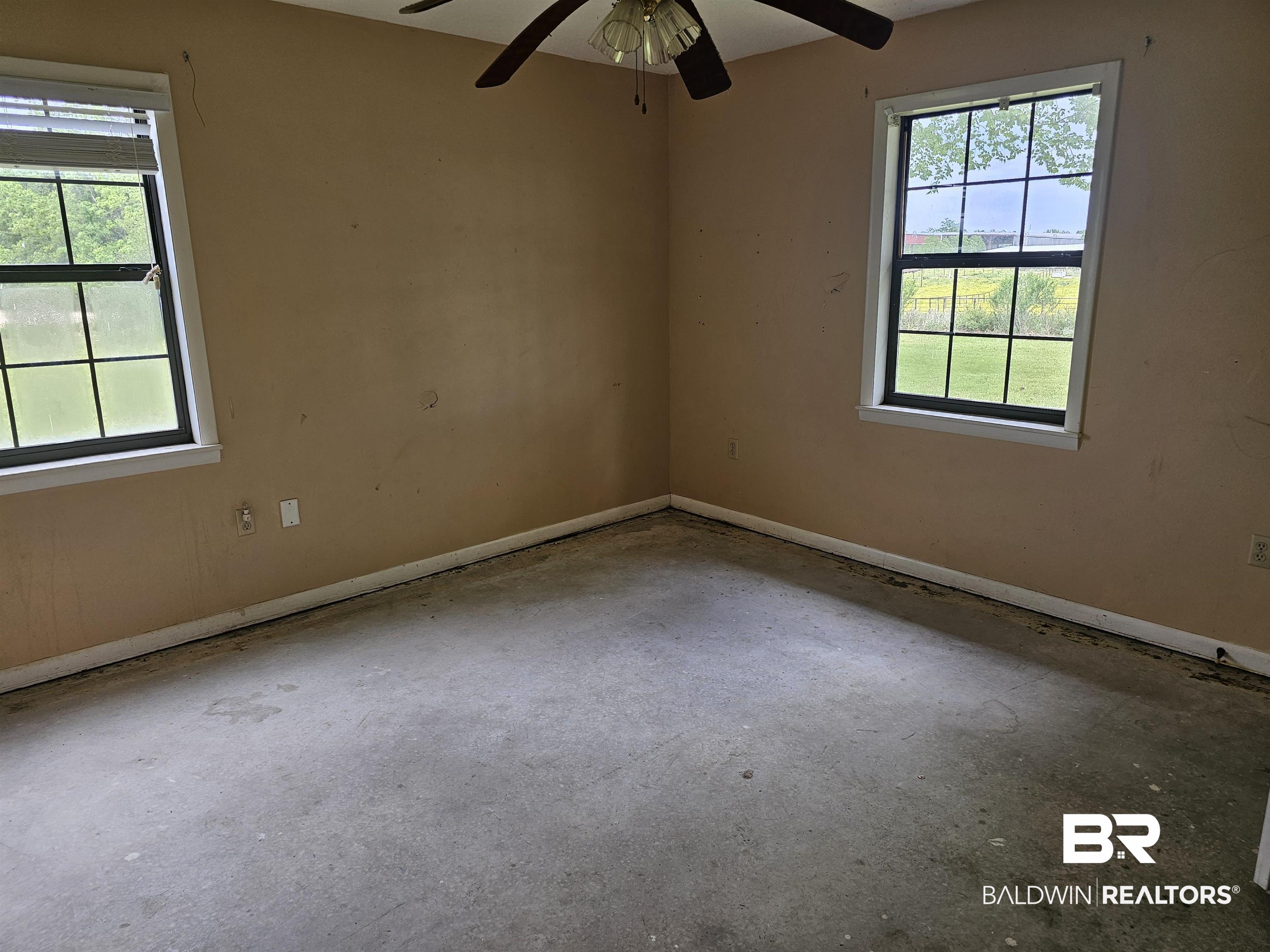 59575 Lottie Road Atmore, AL 36502 - Photo 18 of 23 Unfurnished room featuring a healthy amount of sunlight, ceiling fan, and unfinished concrete flooring