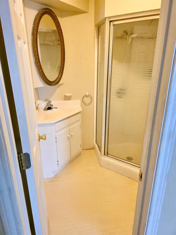 417 West Huffman Street Krum, TX 76249 - Photo 11 of 26 Bathroom featuring a corner shower enclosure and a vanity with a white countertop