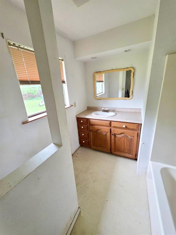 417 West Huffman Street Krum, TX 76249 - Photo 16 of 26 Vanity with wood-finish cabinetry, integrated sink, and countertop