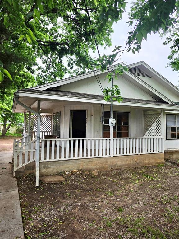 417 West Huffman Street Krum, TX 76249 - Photo 2 of 26 Front exterior featuring a covered porch with white railing, a gabled roofline, and lattice detailing
