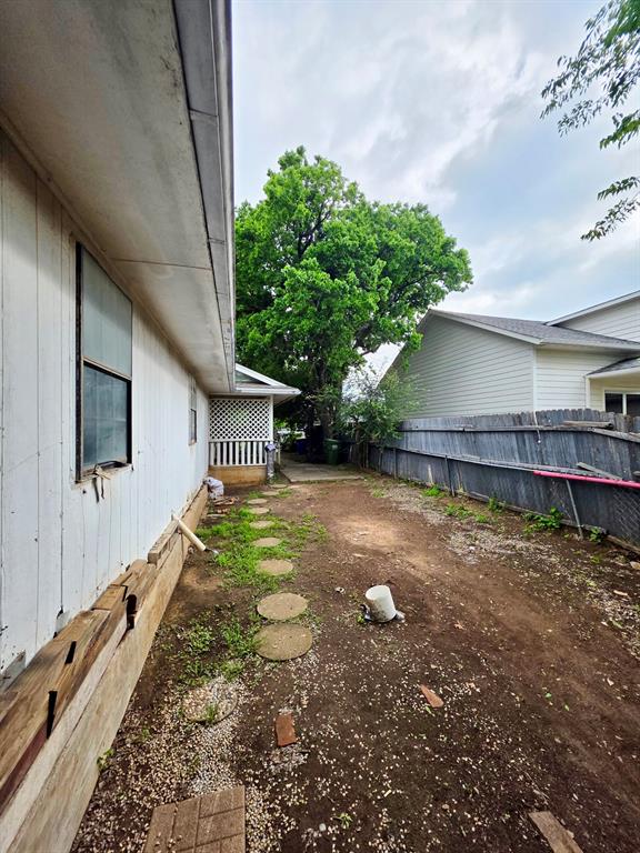 417 West Huffman Street Krum, TX 76249 - Photo 23 of 26 Spacious side yard featuring a partial privacy fence and stepping stone pathway