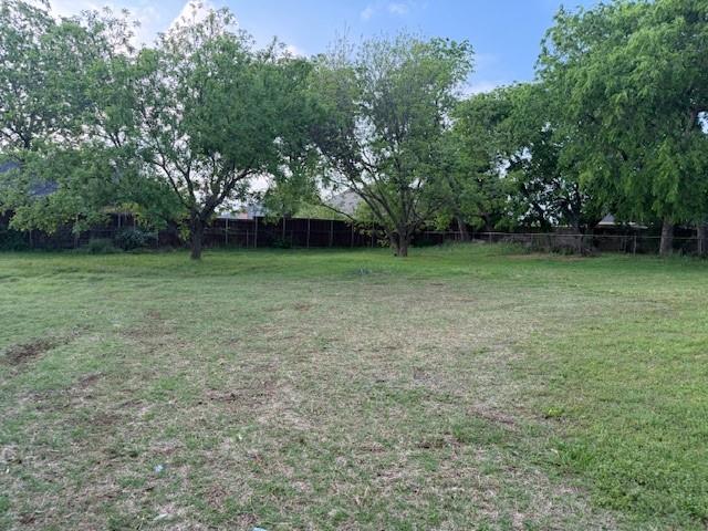417 West Huffman Street Krum, TX 76249 - Photo 25 of 26 The property features an expansive lawn area with several mature trees, providing natural landscaping