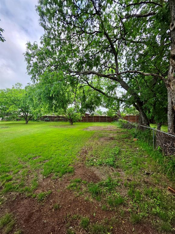 417 West Huffman Street Krum, TX 76249 - Photo 26 of 26 Expansive yard space featuring mature trees and a chain-link fence
