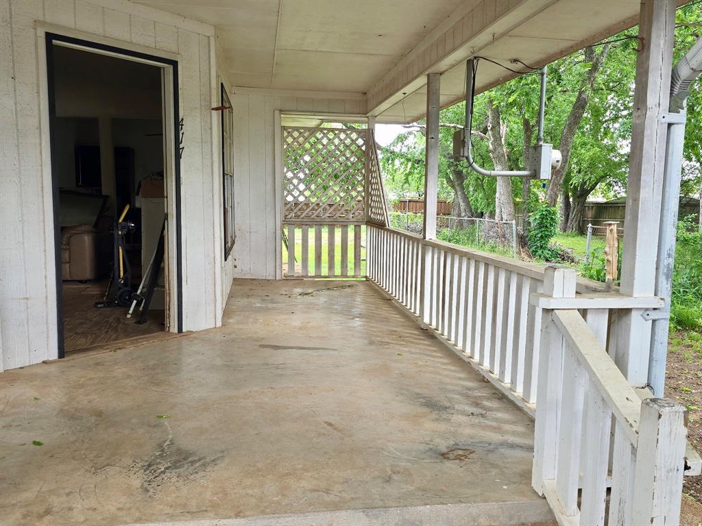 417 West Huffman Street Krum, TX 76249 - Photo 4 of 26 Expansive covered porch featuring a concrete slab, painted wood siding, and white wood railing