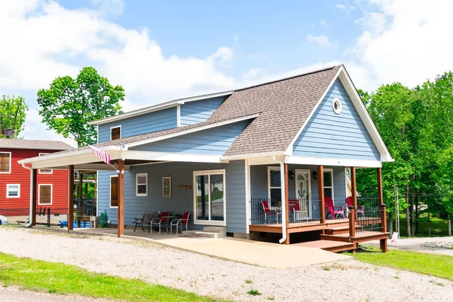 a view of a house with a yard and large tree
