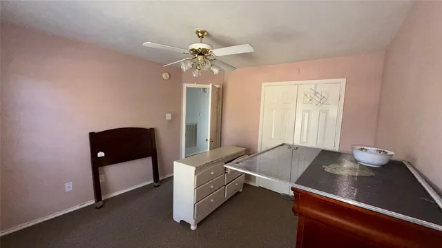 a room with chandelier fan and windows