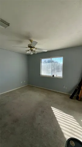 a view of a livingroom with a ceiling fan and window