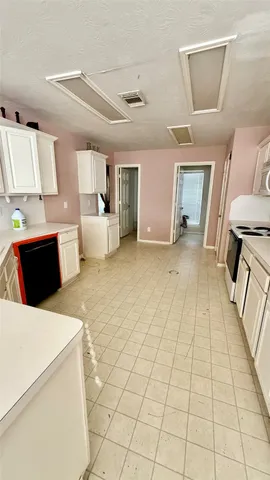 a room with a bed and a view of kitchen