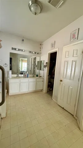 a view of a kitchen with refrigerator and white cabinets