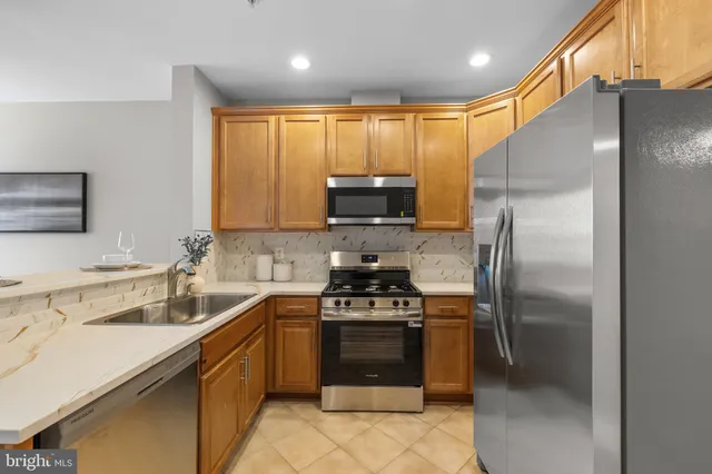 a kitchen with granite countertop a refrigerator and a sink