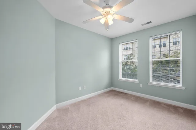 an empty room with a window and a fan