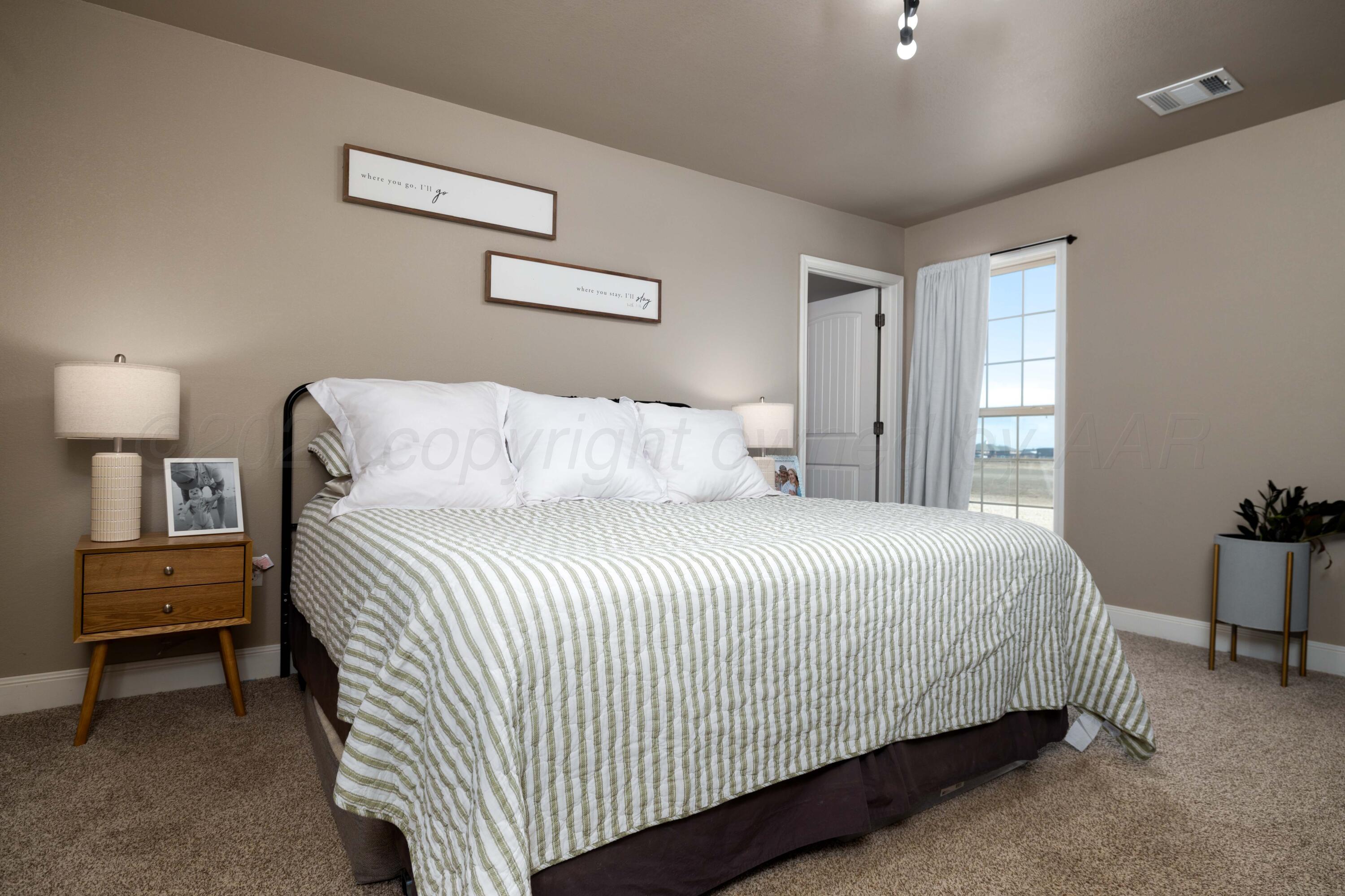 9834 Remington Road Canyon, TX 79015 - Photo 15 of 46 a bedroom with a bed and a night stand