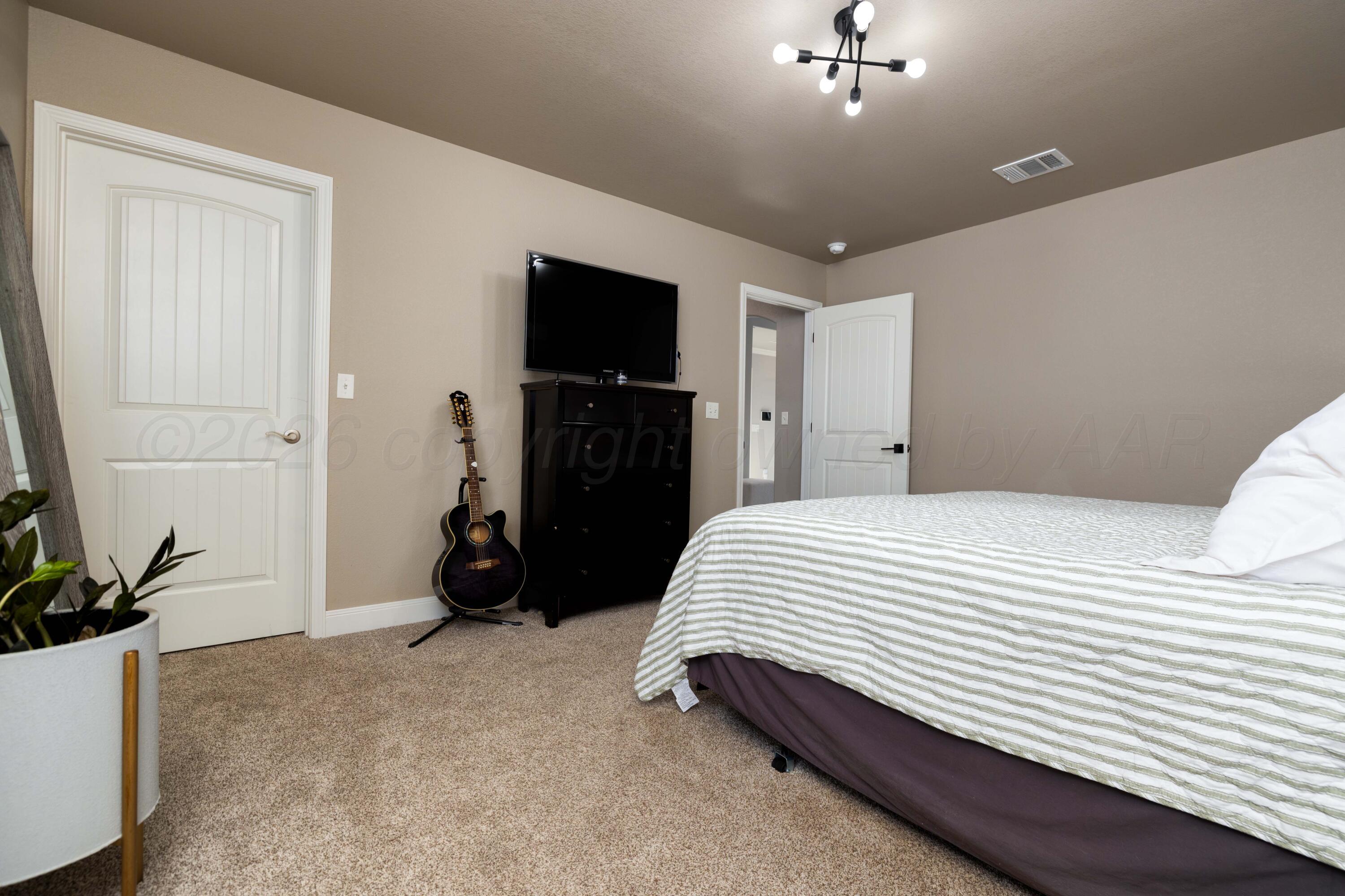 9834 Remington Road Canyon, TX 79015 - Photo 18 of 46 a bedroom with a bed and a flat tv screen on the dresser