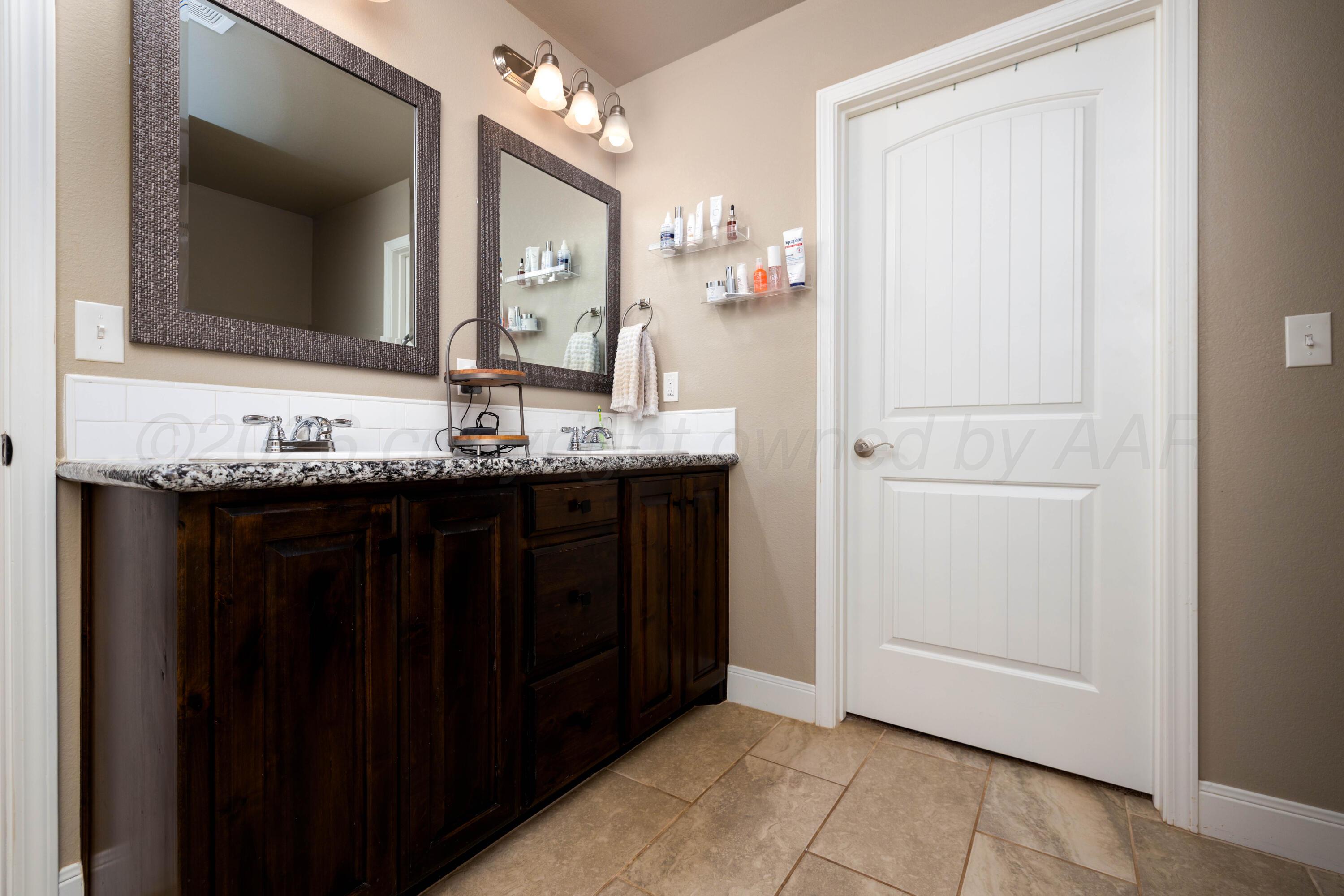 9834 Remington Road Canyon, TX 79015 - Photo 20 of 46 a bathroom with a granite countertop sink and a mirror