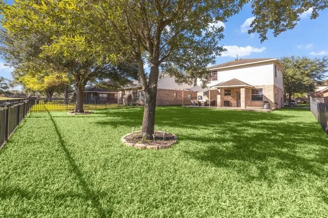 a front view of a house with a yard and trees