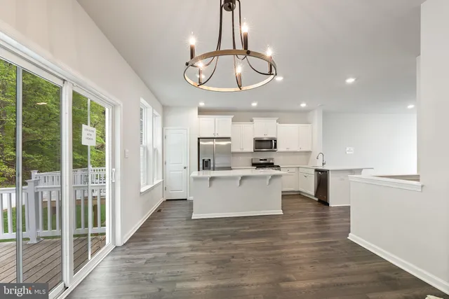 a large white kitchen with a large window appliances and cabinets