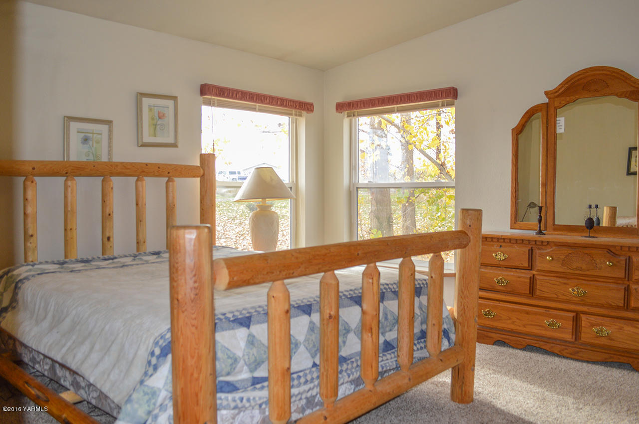 571 Cook Hill Road Yakima, WA 98908 - Photo 8 of 21 a large bedroom with a large bed and windows