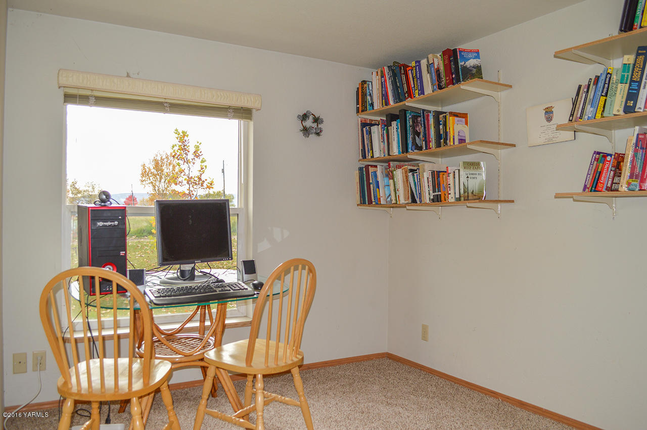 571 Cook Hill Road Yakima, WA 98908 - Photo 9 of 21 a view of a workspace with furniture and a book shelf