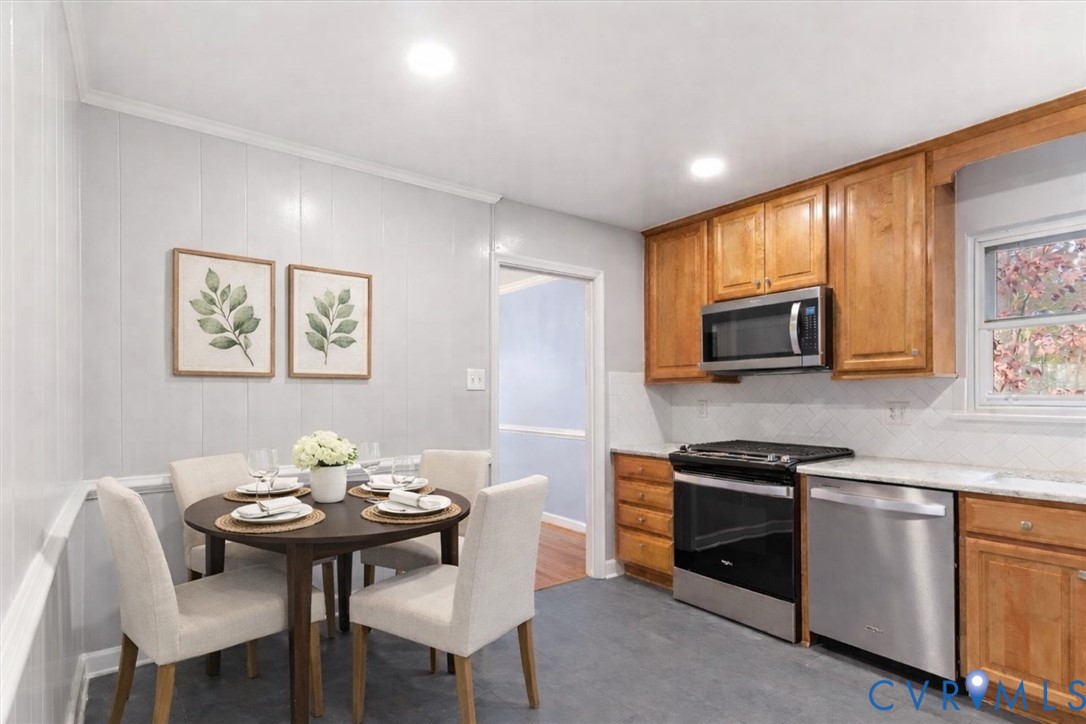 2502 Landon Road Richmond, VA 23294 - Photo 13 of 26 a kitchen with stainless steel appliances kitchen island granite countertop a stove a sink a microwave a dining table and chairs with wooden floor
