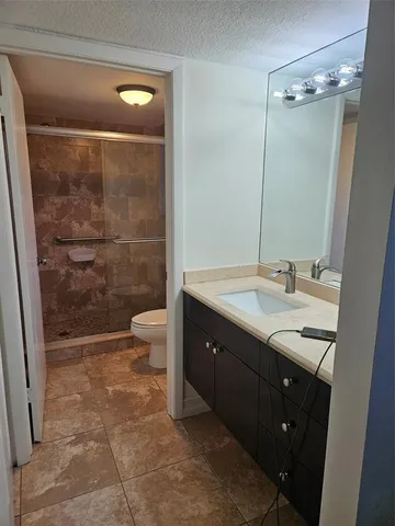 a bathroom with a double vanity sink toilet and shower
