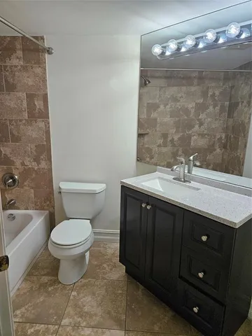 a view of an empty room with chandelier fan