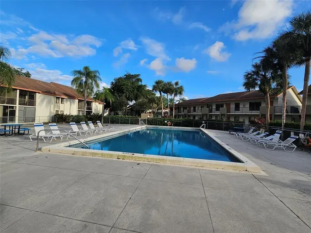 a view of swimming pool with outdoor seating and a patio