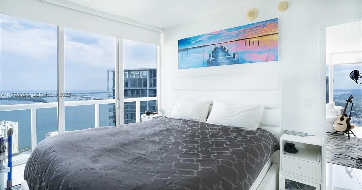 475 Brickell Avenue, Unit 5707 Miami, FL 33131 - Photo 3 of 16 a bedroom with a bed and a chandelier