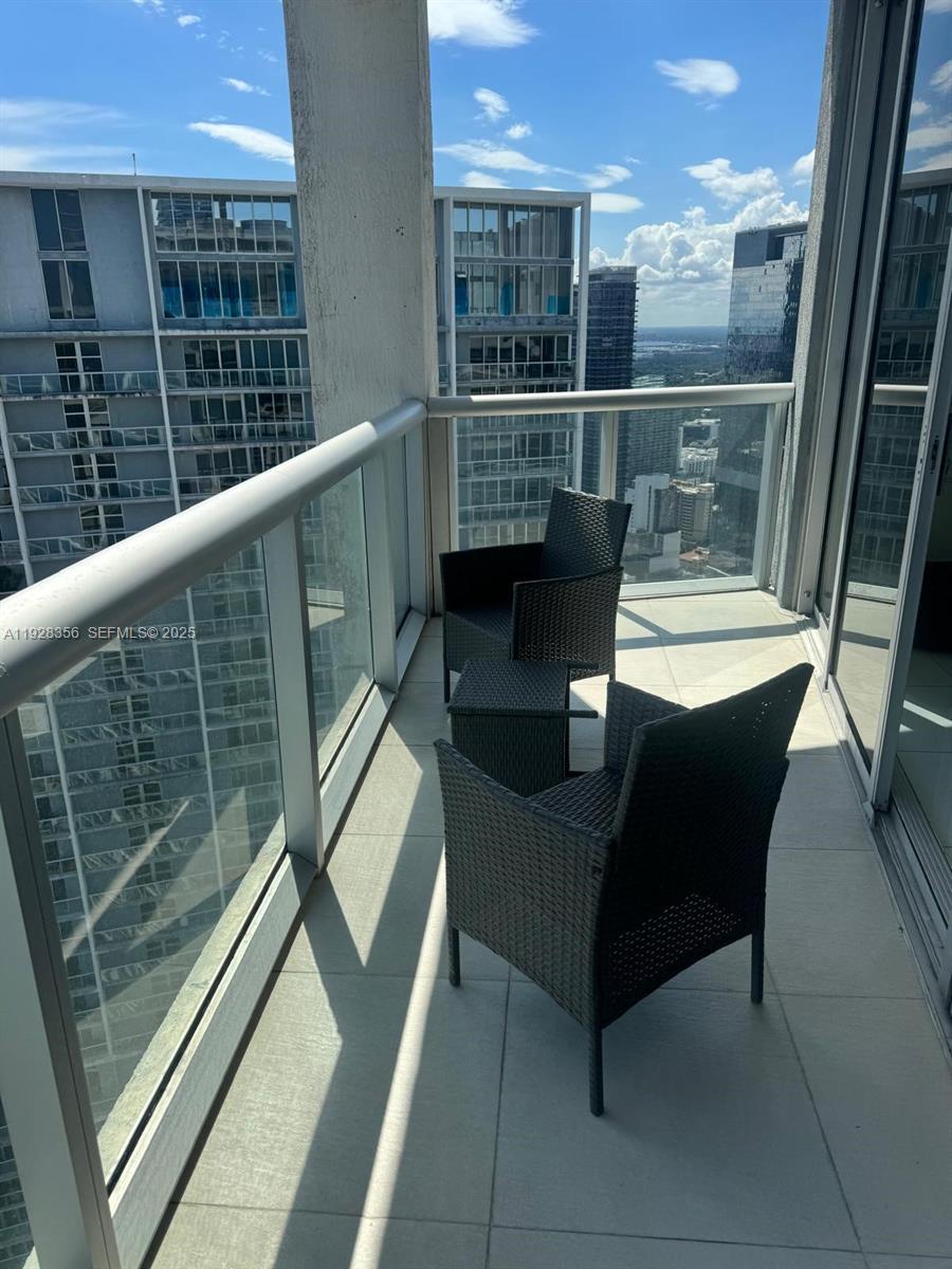 475 Brickell Avenue, Unit 5707 Miami, FL 33131 - Photo 9 of 16 a view of a chairs and table on the balcony