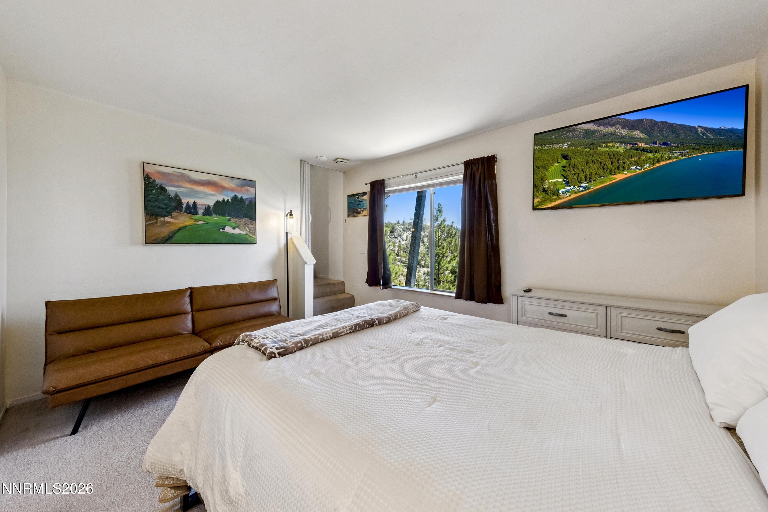 261 Quaking Aspen Lane, Unit D Stateline, NV 89449 - Photo 39 of 44 a bedroom with a bed and a painting on the wall