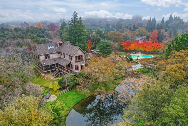 an aerial view of a house with a garden and trees