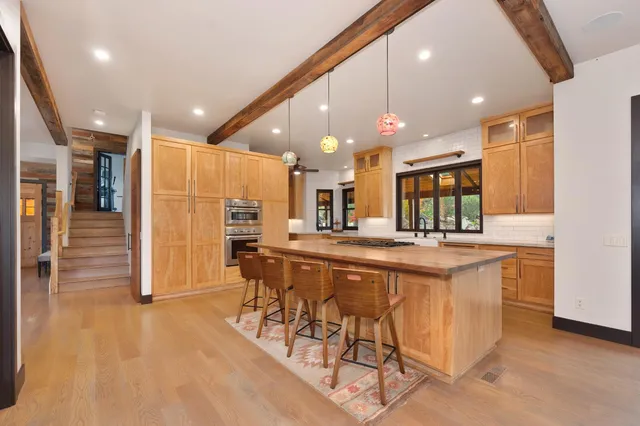 a large kitchen with stainless steel appliances granite countertop a large counter top and a stove
