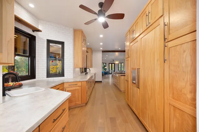 a spacious bedroom with a large bed and a chandelier fan