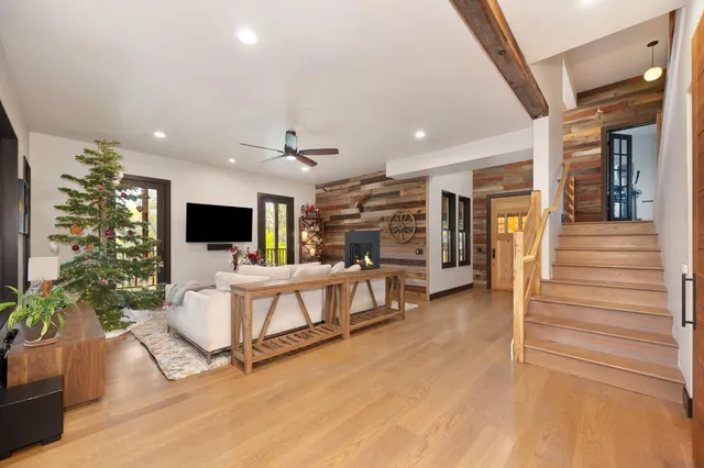 a view of a kitchen with kitchen island stainless steel appliances wooden floor dining table and chairs