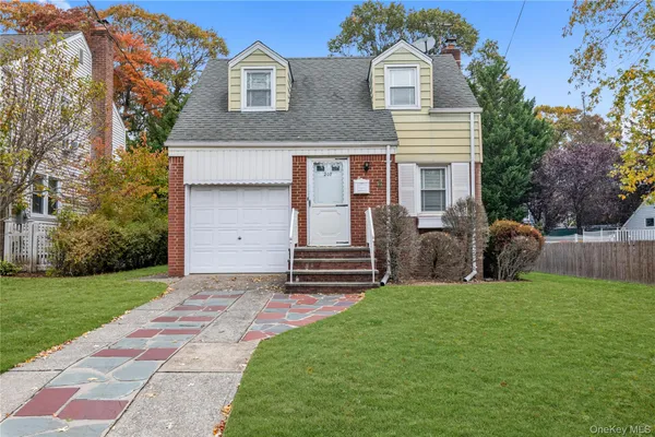 a front view of a house with a garden and yard