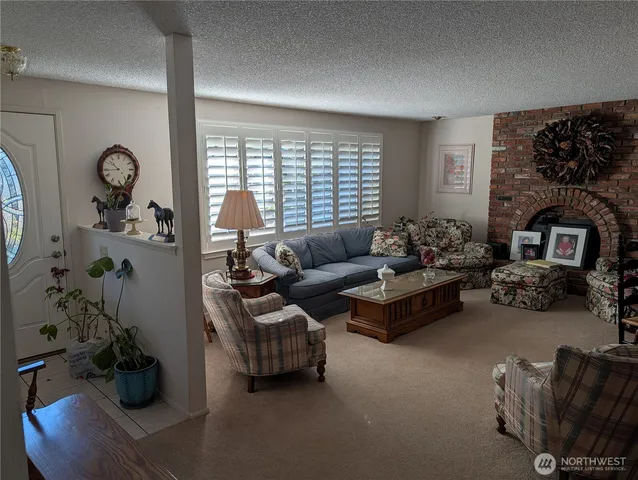 a living room with furniture a fireplace and a large window