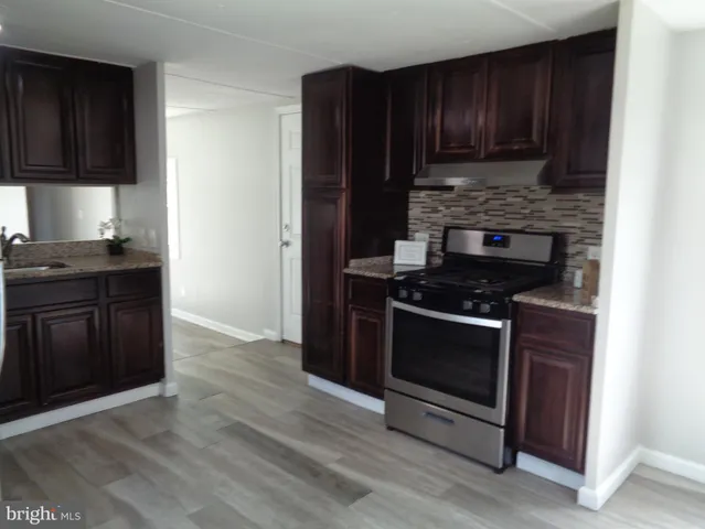 a kitchen with granite countertop wooden cabinets and stainless steel appliances