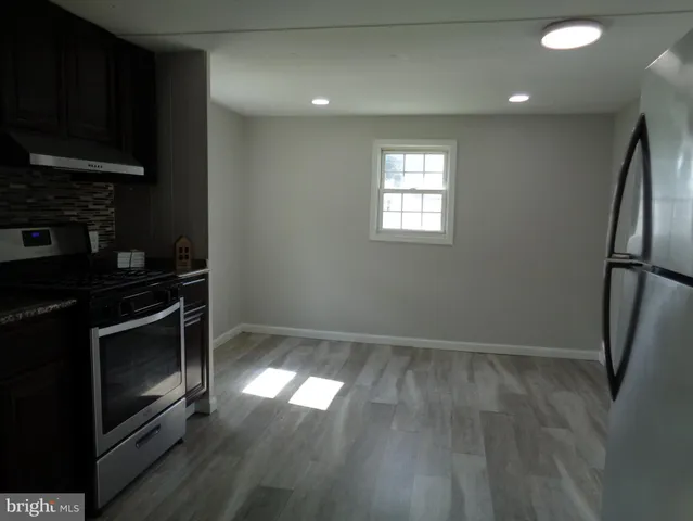 a kitchen with a wooden floor and a stove top oven