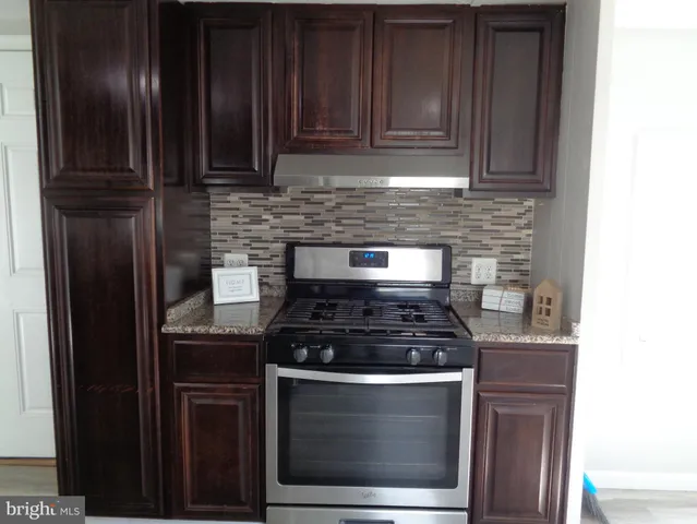 a stove top oven sitting inside of a kitchen