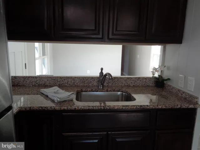 a kitchen with granite countertop a sink stainless steel appliances and cabinets