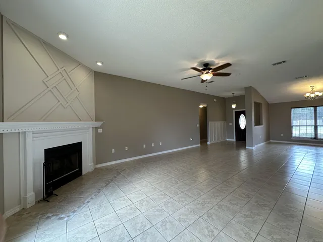 an empty room with fireplace and fan