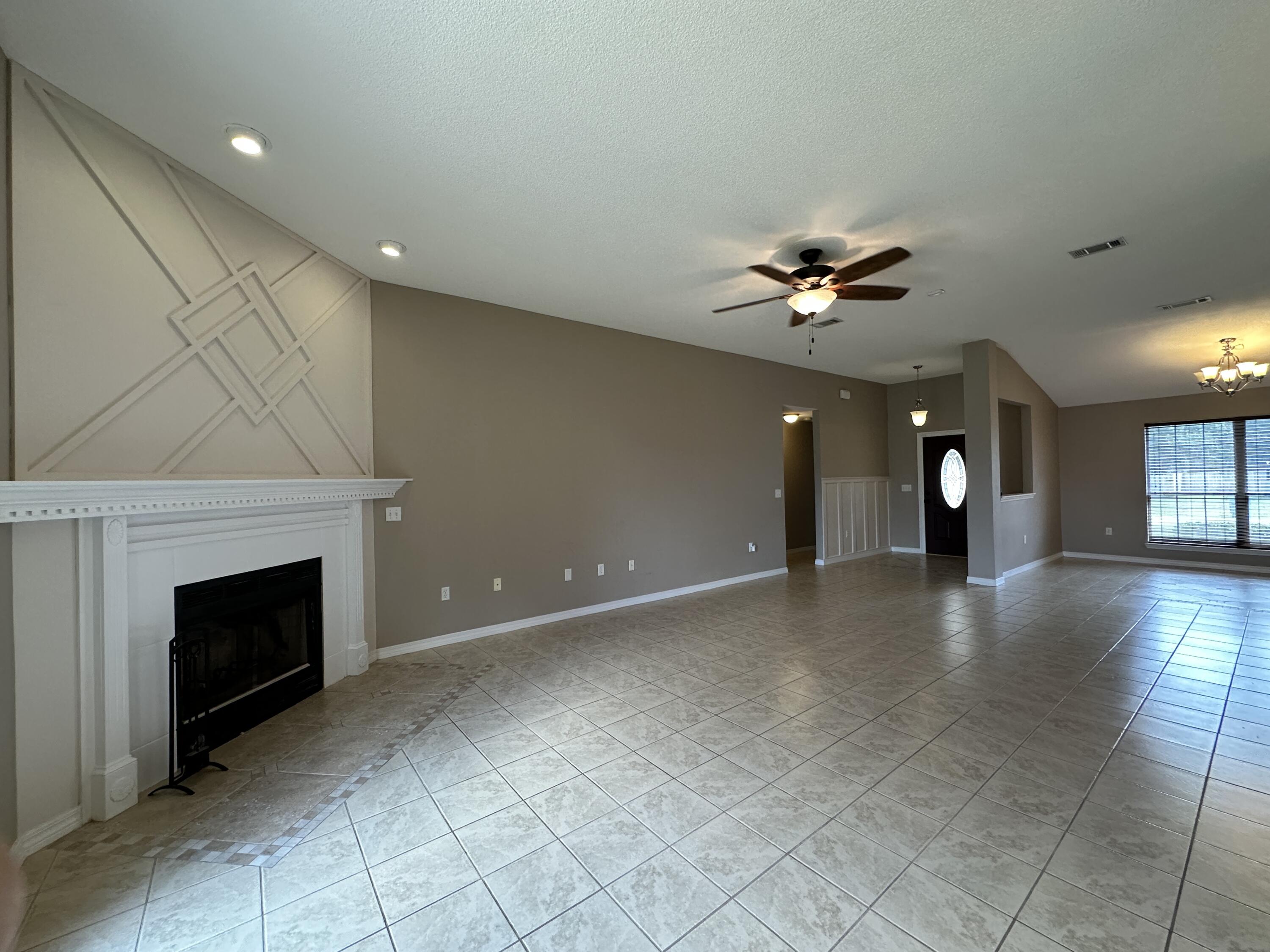 3077 Border Creek Drive Crestview, FL 32539 - Photo 12 of 33 an empty room with fireplace and fan